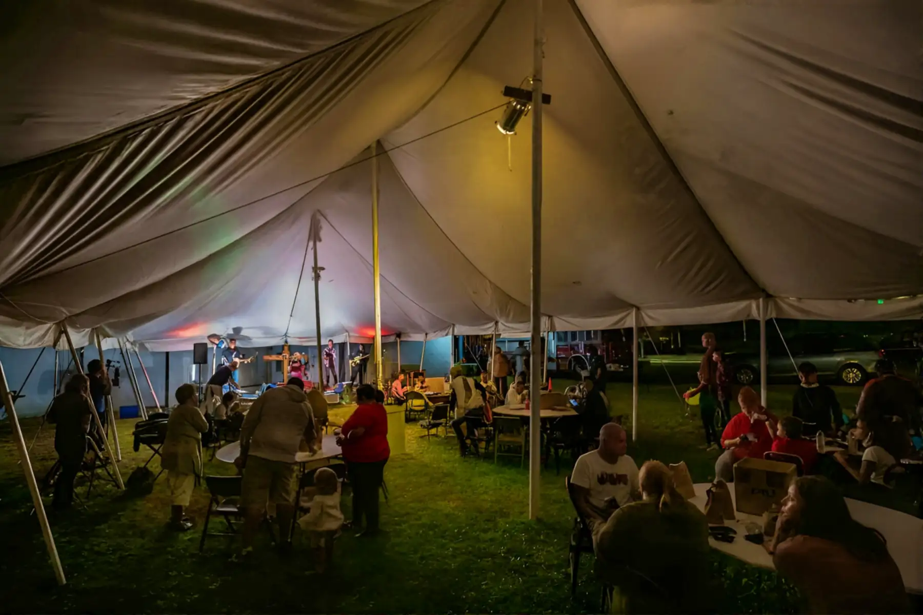 Evening worship service under tent with community fellowship and worship