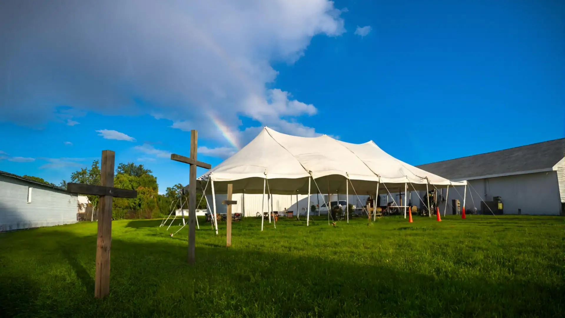 Light of the World outdoor revival tent with crosses and rainbow