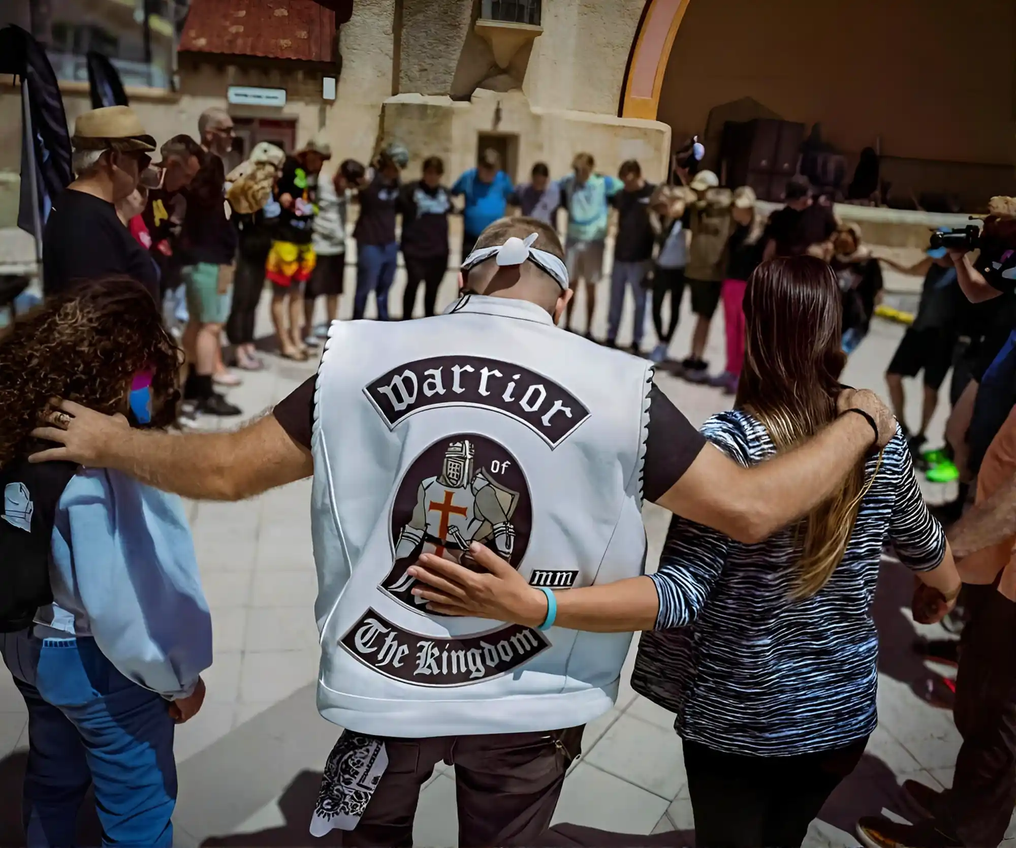 Warrior of Faith ministry members in prayer circle, showing brotherhood and unity in Christ